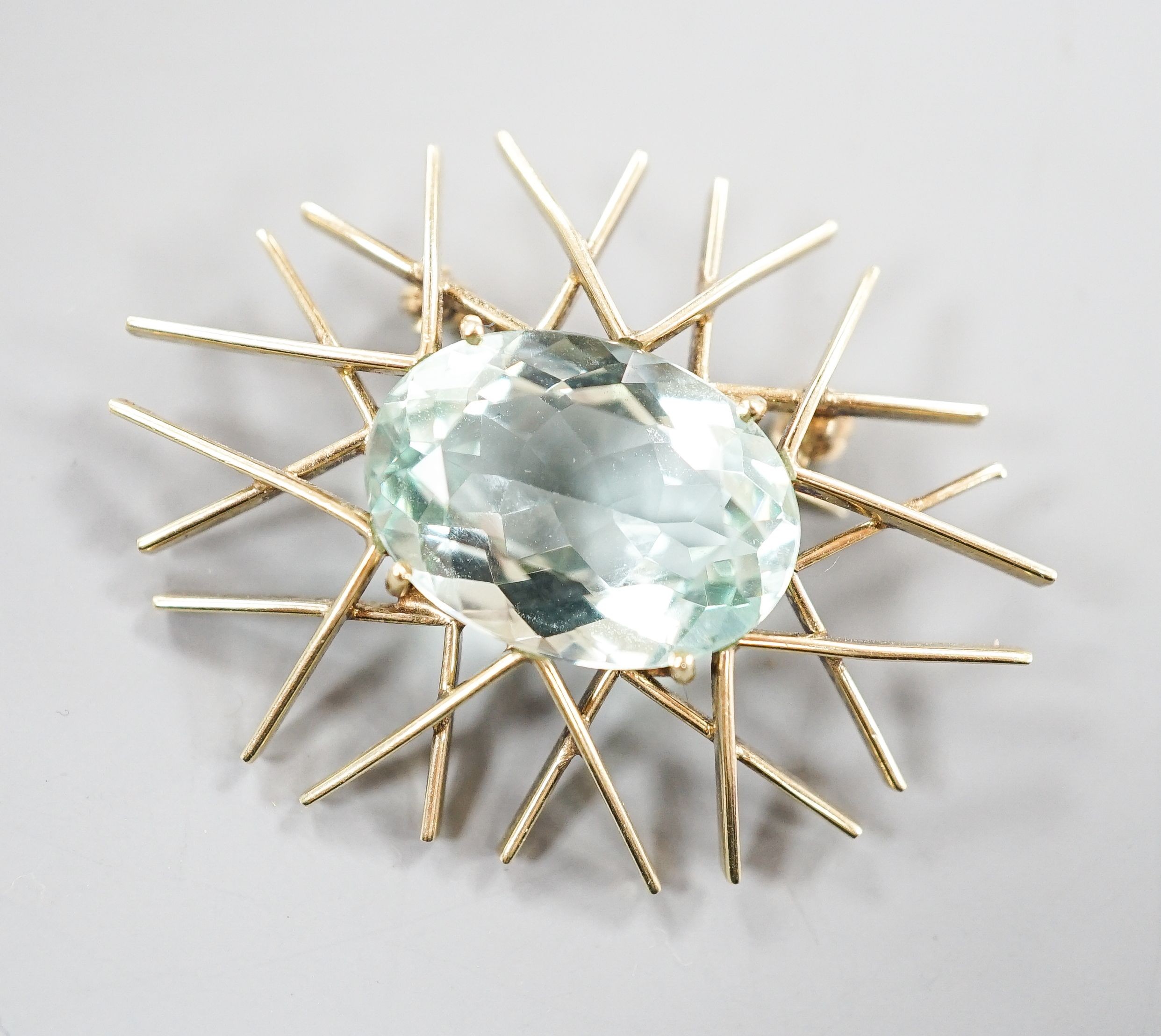 A 1960's 585 yellow metal and oval cut aquamarine set modernist brooch, 39mm, gross 7.5 grams.